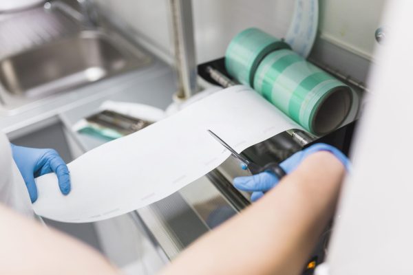 nurse-cutting-plastic-from-pouch-sealer-packaging-machinery