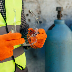 worker-with-gloves-holding-protective-glasses worker-with-gloves-holding-protective-glasses